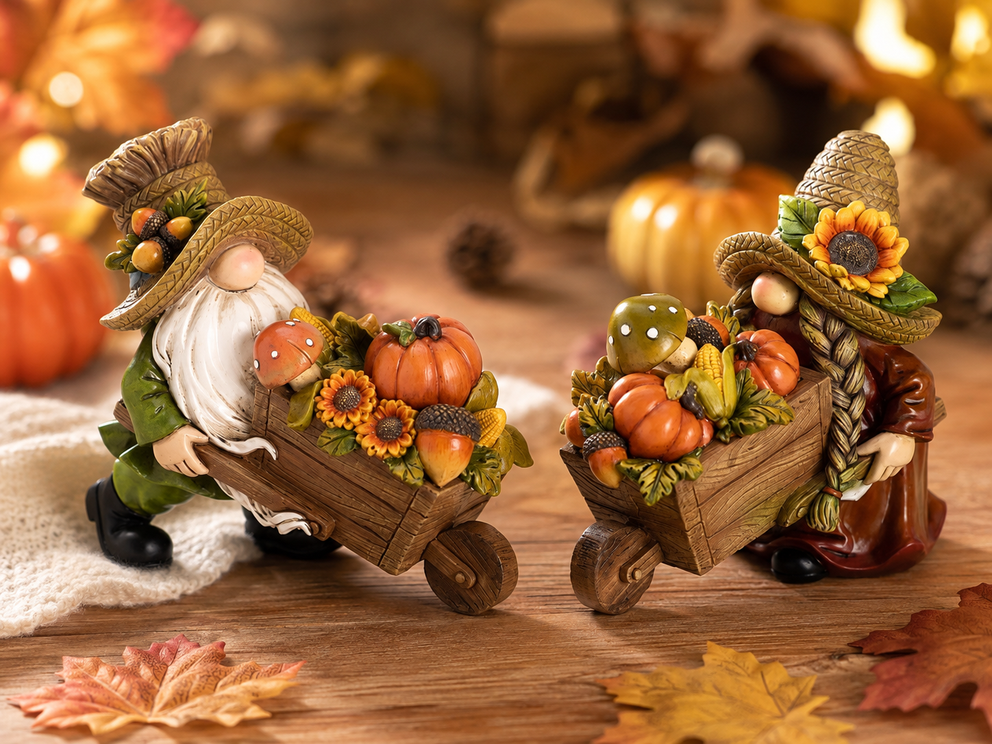 Autumn harvest gnome figurines with pumpkins and wheelbarrows